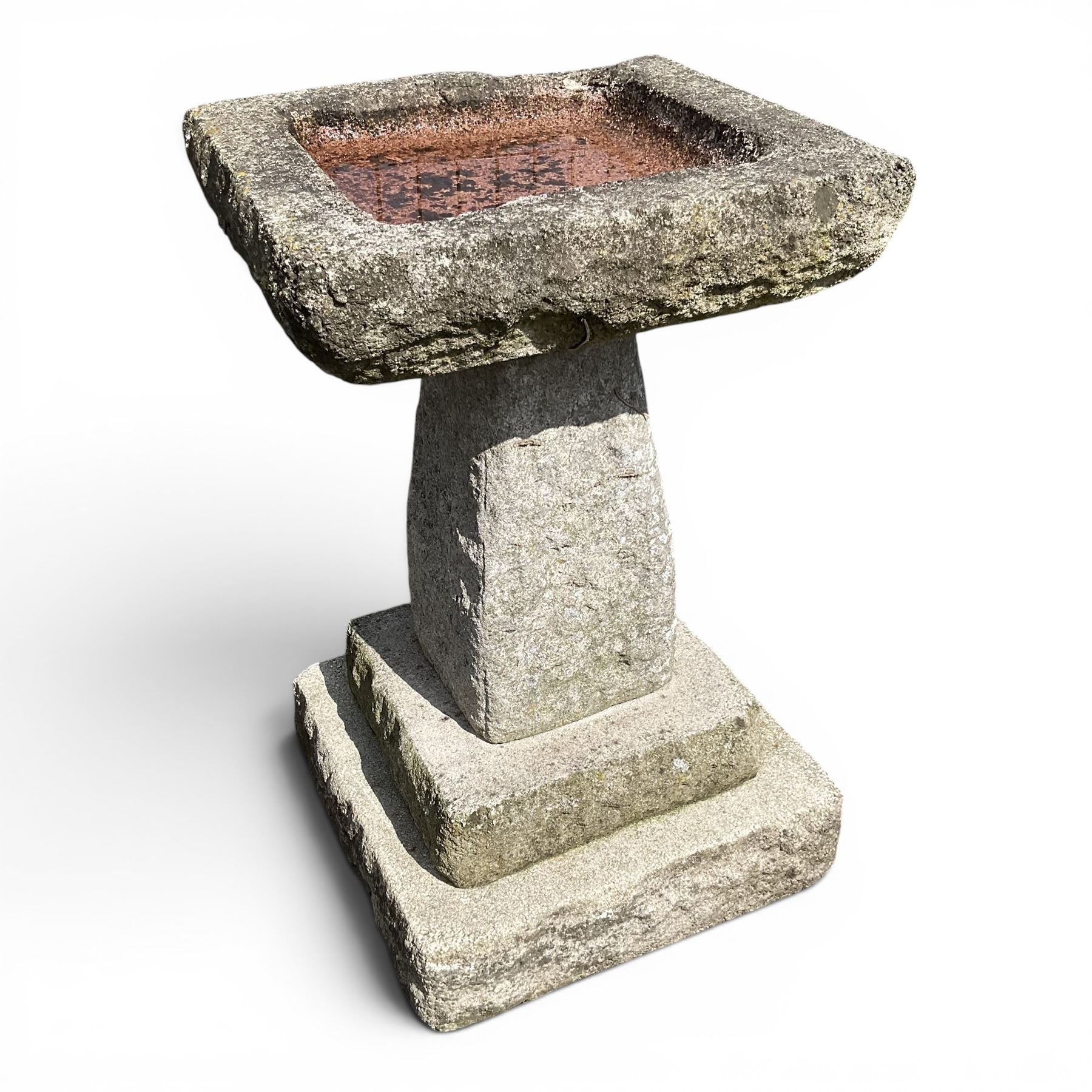 Early 20th century composite three-piece stone birdbath, square dished top on tapering pedestal and stepped base