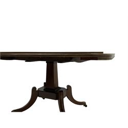 Regency mahogany dining table, rectangular top with rounded corners and reeded edge, raised on square pedestal with platform, terminating to sabre supports with brass cups and castors