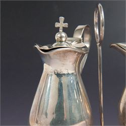 Ecclesiastical silver cruets, comprising two jugs in the form of miniature wine carafes, one hallmarked London 1825, the other unmarked, contained in a silver cruet stand with loop handle, hallmarked London 1937, and a French silver jar and cover in the form of a miniature chalice, with Minerva's head standard mark, tallest H13cm