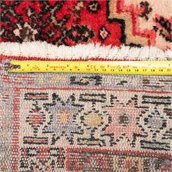 Persian crimson ground runner rug, the field decorated with repeating Herati motifs around an ivory pendant medallion, stepped ivory spandrels with stylised floral ornament, enclosed by a dark ground star border and narrow guard stripes