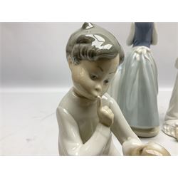 Four Lladro figures, comprising Ironing Time no 4981, Boy with Dog no 4522,  Boy Awakening no 4870 and Teaching to Pray no 4779, together with two Lladro plaques, largest example H26cm