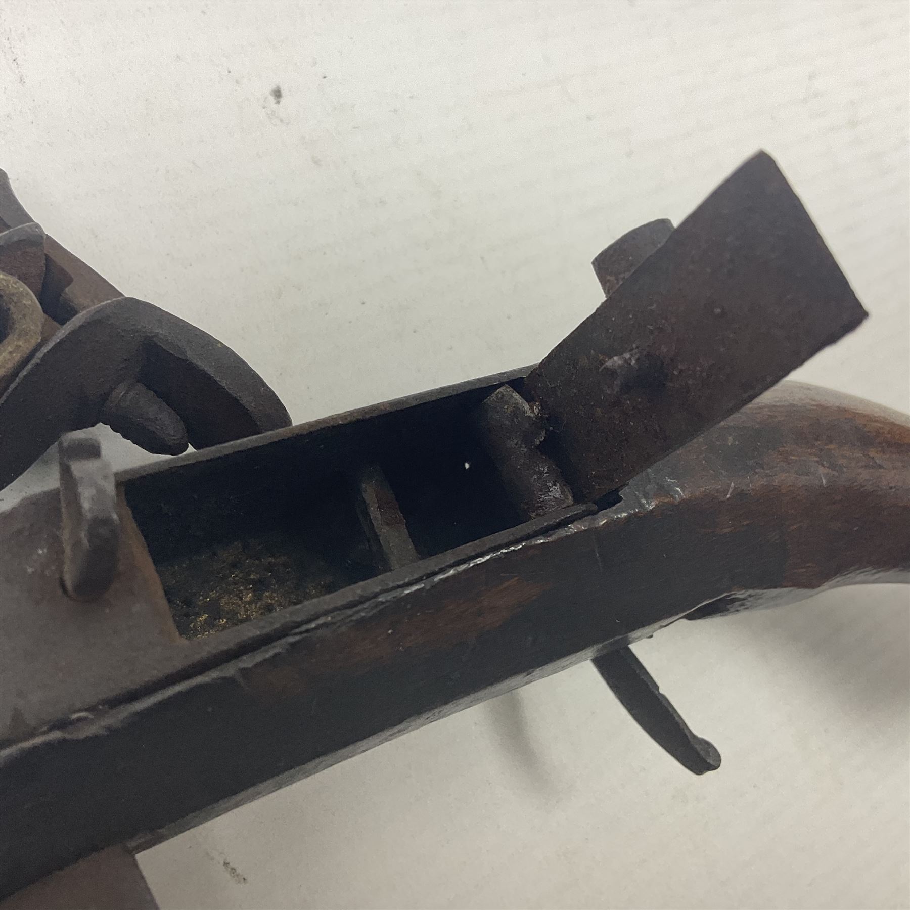 Late 18th/early 19th century flintlock tinder lighter, the steel box lock with hinged door to the left side, fruitwood butt with plain bar trigger, the left side set with a taper sconce and bipod front support, L21cm.