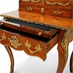 Late 19th century French Louis XV style kingwood and ormolu mounted bonheur du jour, the upper section with a pierced three-quarter gallery over a pair of cupboard doors inset with Sèvres-style porcelain portrait plaques, enclosing a shelved interior over two short drawers, the serpentine top and apron richly mounted with gilt-bronze foliate and scroll motifs, single frieze drawer below on cabriole supports with acanthus cast sabots