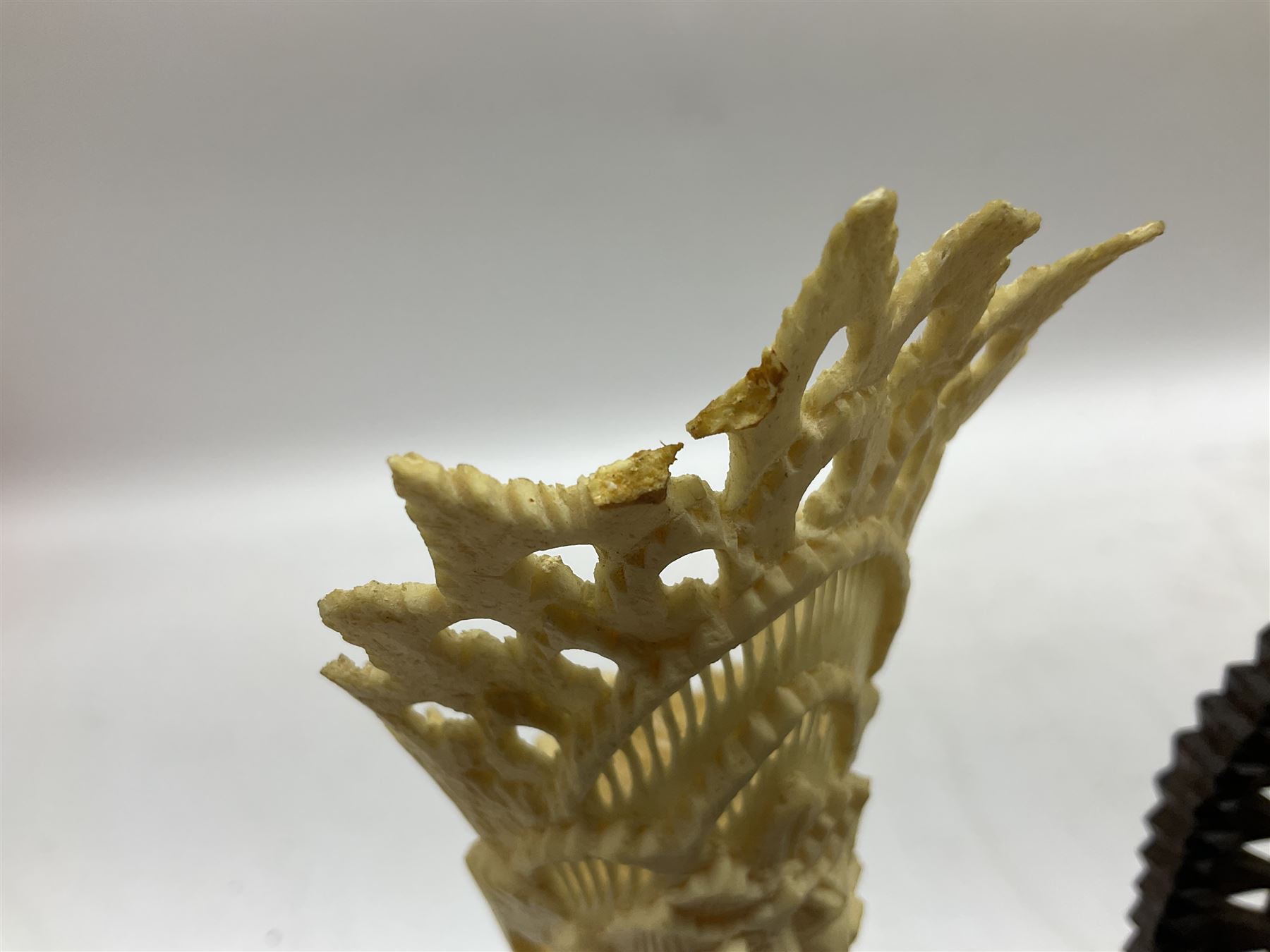 Hardwood bust of an Indoniesian Goddess, carved wearing a pierced headdress, from Klungkung, Bali, H20cm, together with a pair of bone carvings of deity figures, and a carved wood Netsuke in the form of a Chinese dragon