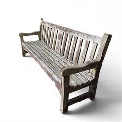 Teak garden bench with slatted back and seat on square supports in weathered which finish 