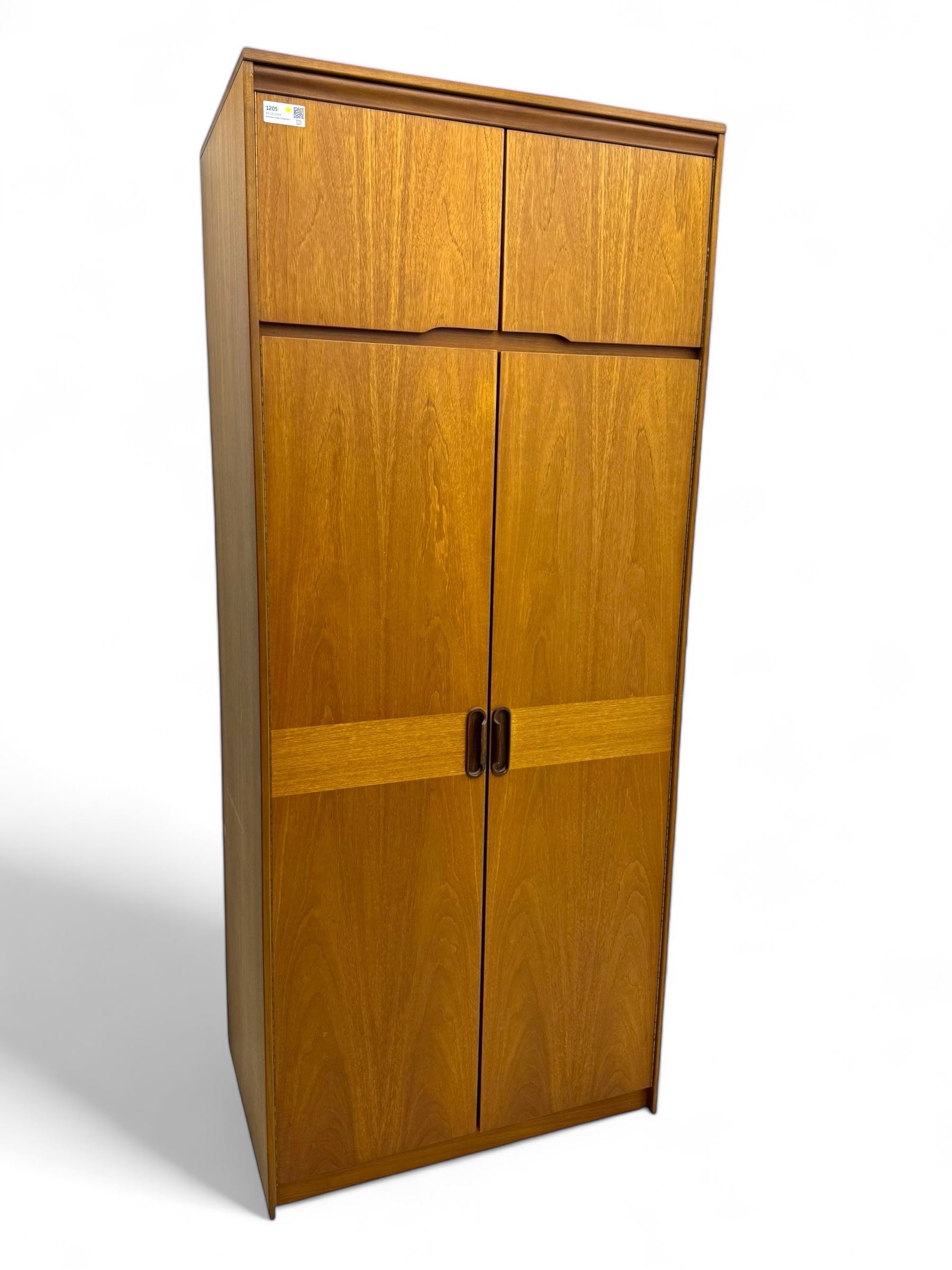 William Lawrence - mid-20th century teak double wardrobe, upper storage section over twin doors featuring recessed handles and contrasting horizontal panel, enclosing hanging rail compartment, towel rail, mirror, shelves and drawer, on plinth base with concealed castors