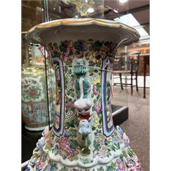 Large pair of 19th century Cantonese famille rose vases, each painted with various courtly scenes, including a display of warriors fighting on horseback before an official and his attendants, double Buddhist lion handles and applied at the shoulders with chilong, the lower band painted with Greek key motif, H58cm (2)