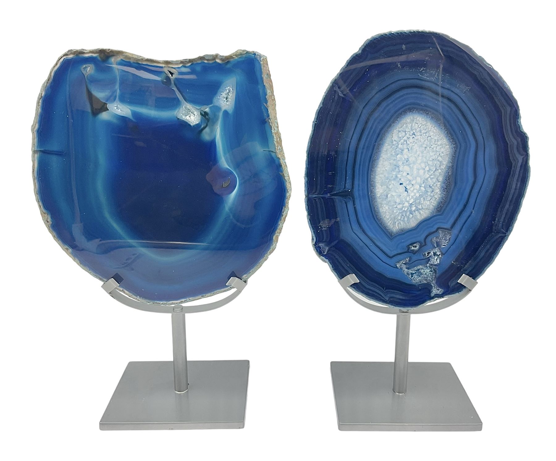 Pair of blue agate slices, polished with rough edges, raised upon silvered metal stands, H26cm