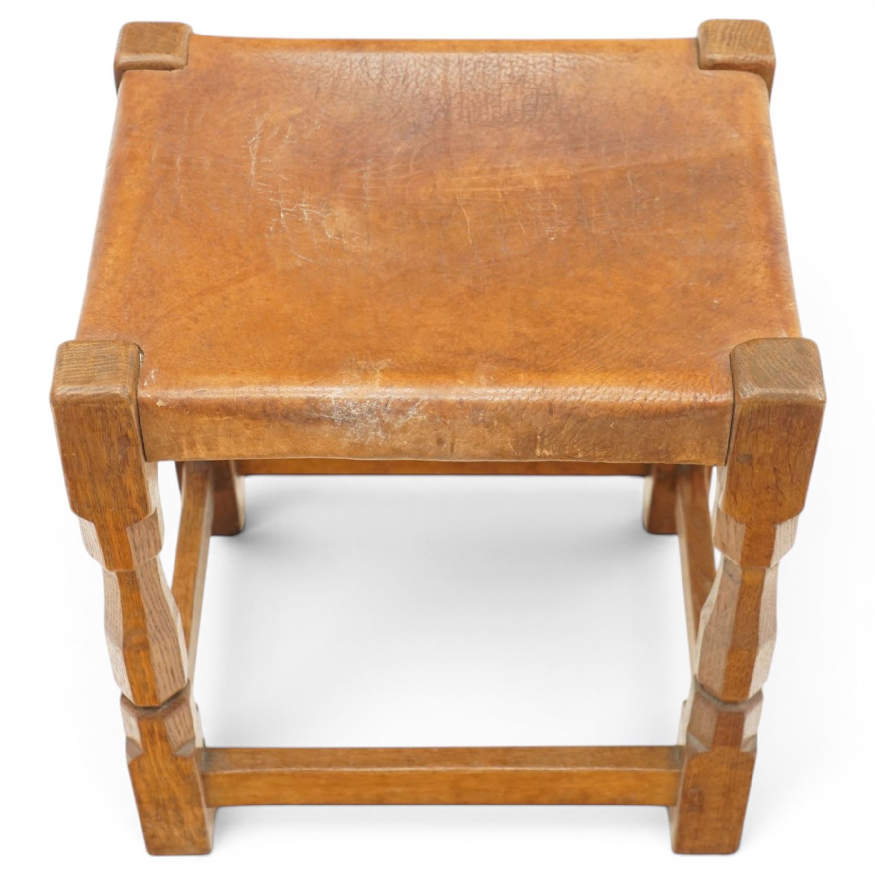 Mouseman - 1950s dark oak dressing table stool, the rectangular top with tan leather seat, raised on octagonal supports united by box stretcher, carved with mouse signature, by the workshop of Robert Thompson of Kilburn