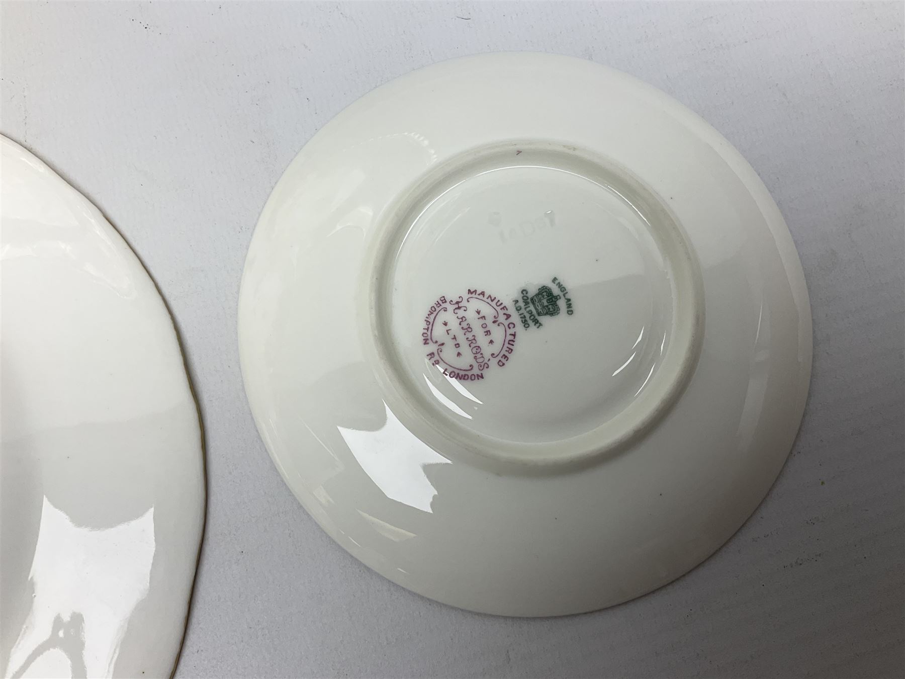 Coalport green batwing pattern tea wares, decorated with finely enamelled floral sprays within gilt reserves, comprising teacup trio, twin handled cake plate and side plate, pattern no Y2665, together with a Coalport for Harrods cup and saucer similarly decorated, the saucer with stamped mark beneath 'Manufactured for Harrods Ltd, Brompton Rd London', all with green Coalport AD 1750 marks beneath, largest W31cm (7)