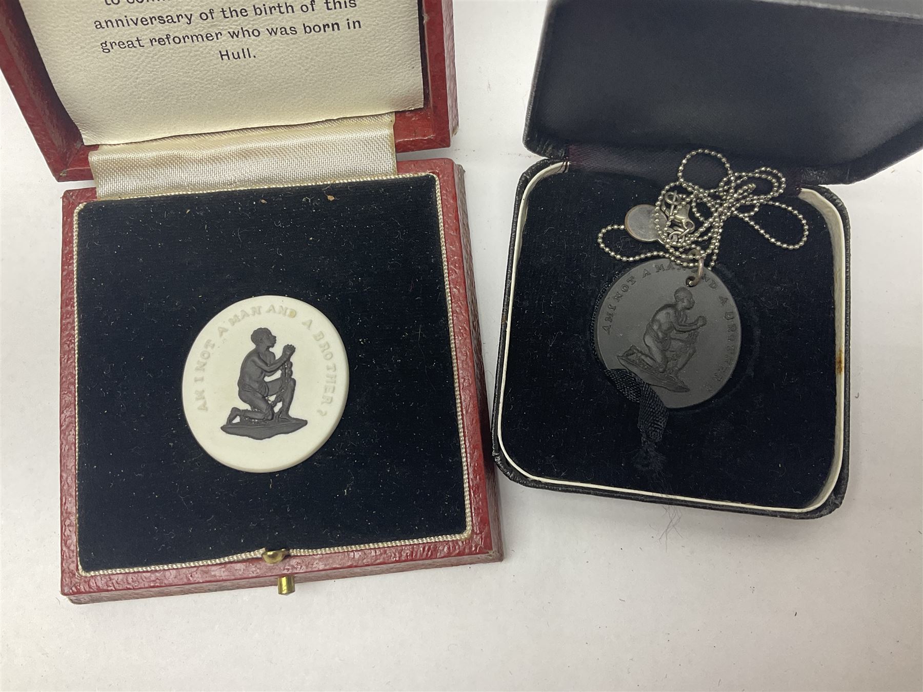 Group of William Wilberforce Abolition of Slavery items, comprising Wedgwood black on cane Jasperware pin tray, Wedgwood light blue Jasperware plate, and two Wedgwood oval medallion pendants, each depicting a kneeling figure beneath the inscription 'AM I NOT A MAN AND A BROTHER?', an Eastgate pottery plaque decorated in relief with a kneeling figure before William Wilberforce, a Hull Museum Publications pamphlet titled 'Medals, Tokens, etc., Issued in Connection with William Wilberforce and the Abolition of Slavery', by Thomas Sheppard, dated 1916, and an antique print depicting William Wilberforce after the original portrait by George Richmond, (7)