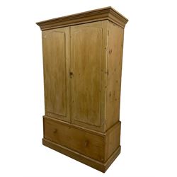 Victorian waxed pine double wardrobe, moulded cornice, enclosed by two doors with applied raised pointed panels, drawer to base on skirt