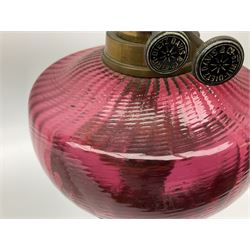 Victorian table standing oil lamp, brass fittings, cranberry glass reservoir, brass column on black enamelled ceramic base, with a frosted glass shade and clear glass chimney, H68cm