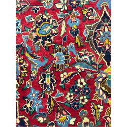 Central Persian Kashan crimson ground rug, central indigo pole medallion surrounded by sparsely placed bouquets interconnected with foliate branches, the guarded border with repeating palmette and Boteh motifs with interwoven scrolling patterns, framed by guard stripes