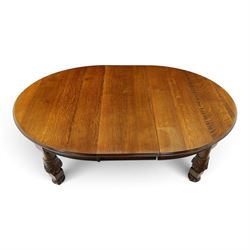 Late 19th century French oak extending dining table, oval top with moulded edge and plain frieze, raised on four ornate carved supports decorate with carved latticework and large festoons with tassels, on turned feet, with two additional leaves