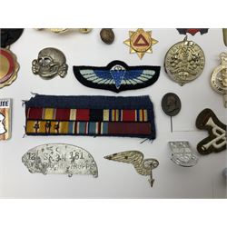 Collection of approximately sixty worldwide medals, metal badges, belt buckles, cloth badges, trench art, brass button stick etc