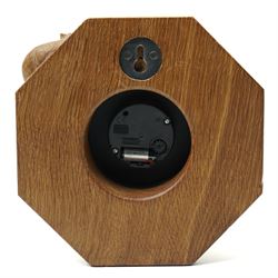 Mouseman - oak wall clock, circular Roman dial in brass drum on moulded octagonal mount, , fitted with battery operated Quartz movement, with carved mouse signature, by the workshop of Robert Thompson of Kilburn