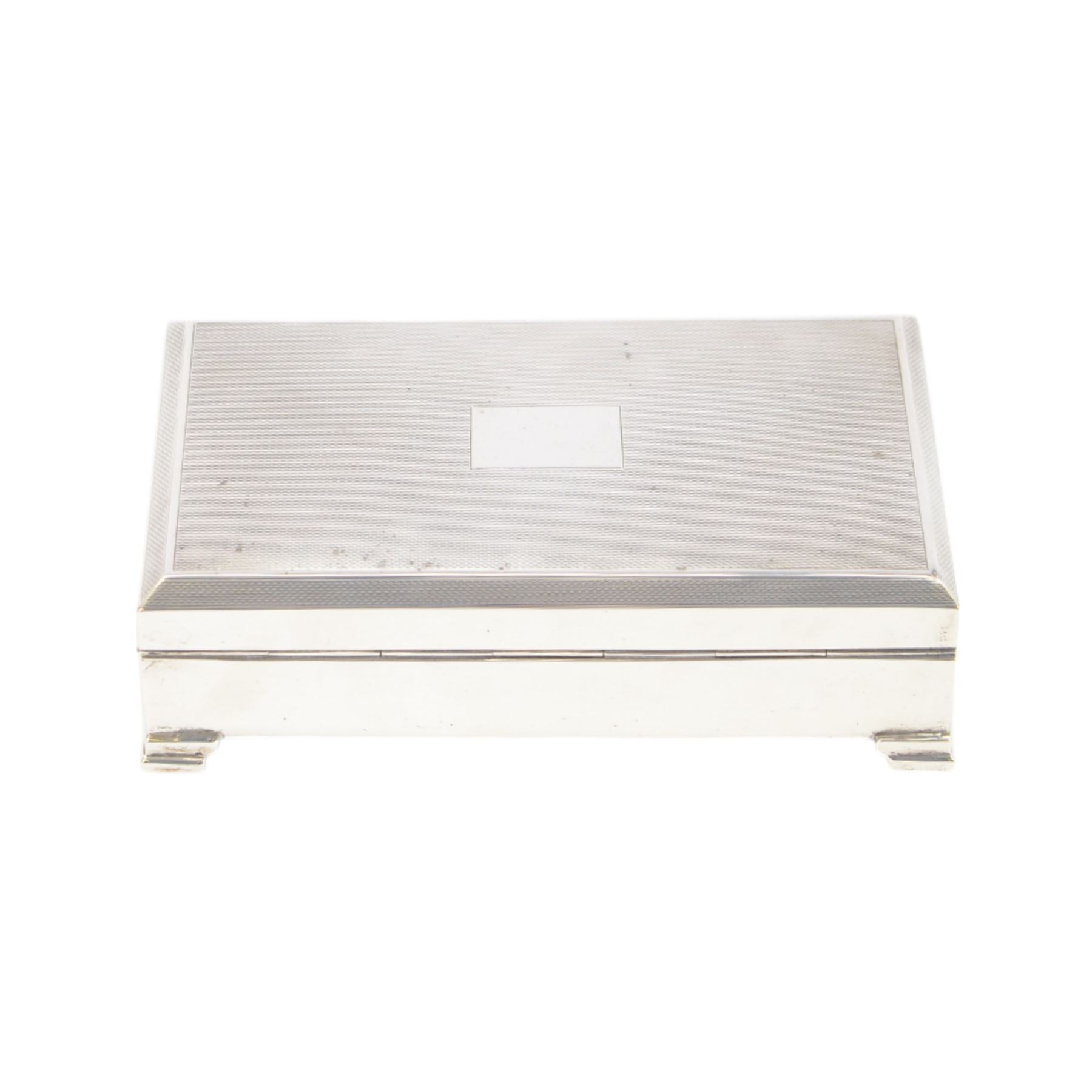 Mid 20th century silver mounted cigarette box, of rectangular form with engine turned decoration to the hinged cover, with vacant rectangular cartouche, opening to reveal a compartmentalised softwood interior, upon four bracket feet, hallmarked Henry Clifford Davis, Birmingham 1964, H4cm, W15cm