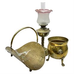 Brass log basket, with swing handle, upon four cast foliate feet, together with a brass planter, of circular bellied form, with lion mask handles and upon three paw feet and a brass oil lamp, with chased and twisted stem and pink frosted frilled  glass shade, lamp H56cm