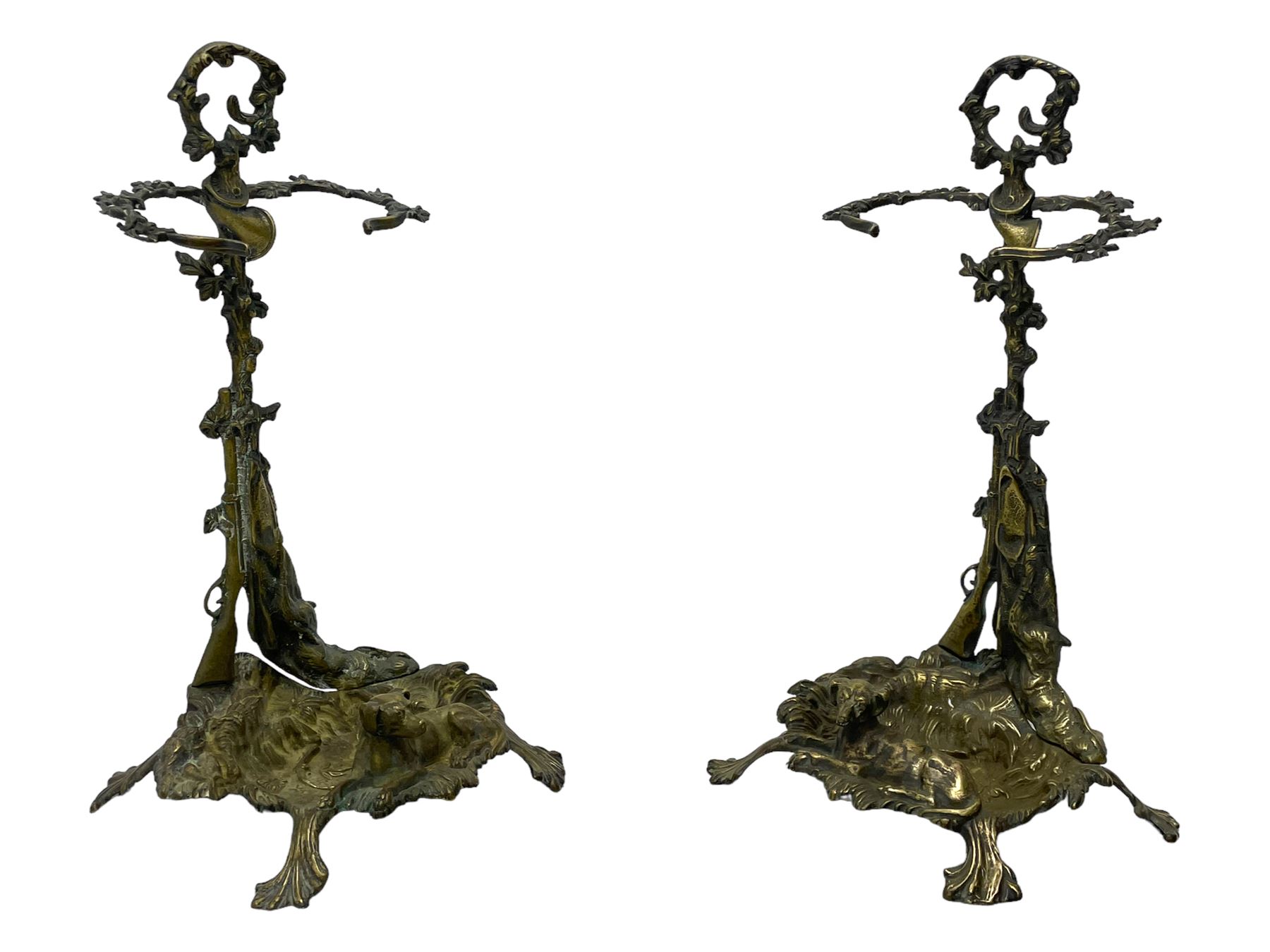 Pair of cast brass hallway umbrella or stick stands, in the form of a tree decorated with trailing flowering foliage branches, the stem with hunting horn over leaning shotgun, shaped naturalist tray base with hunting hound and out splayed foliate cast feet 