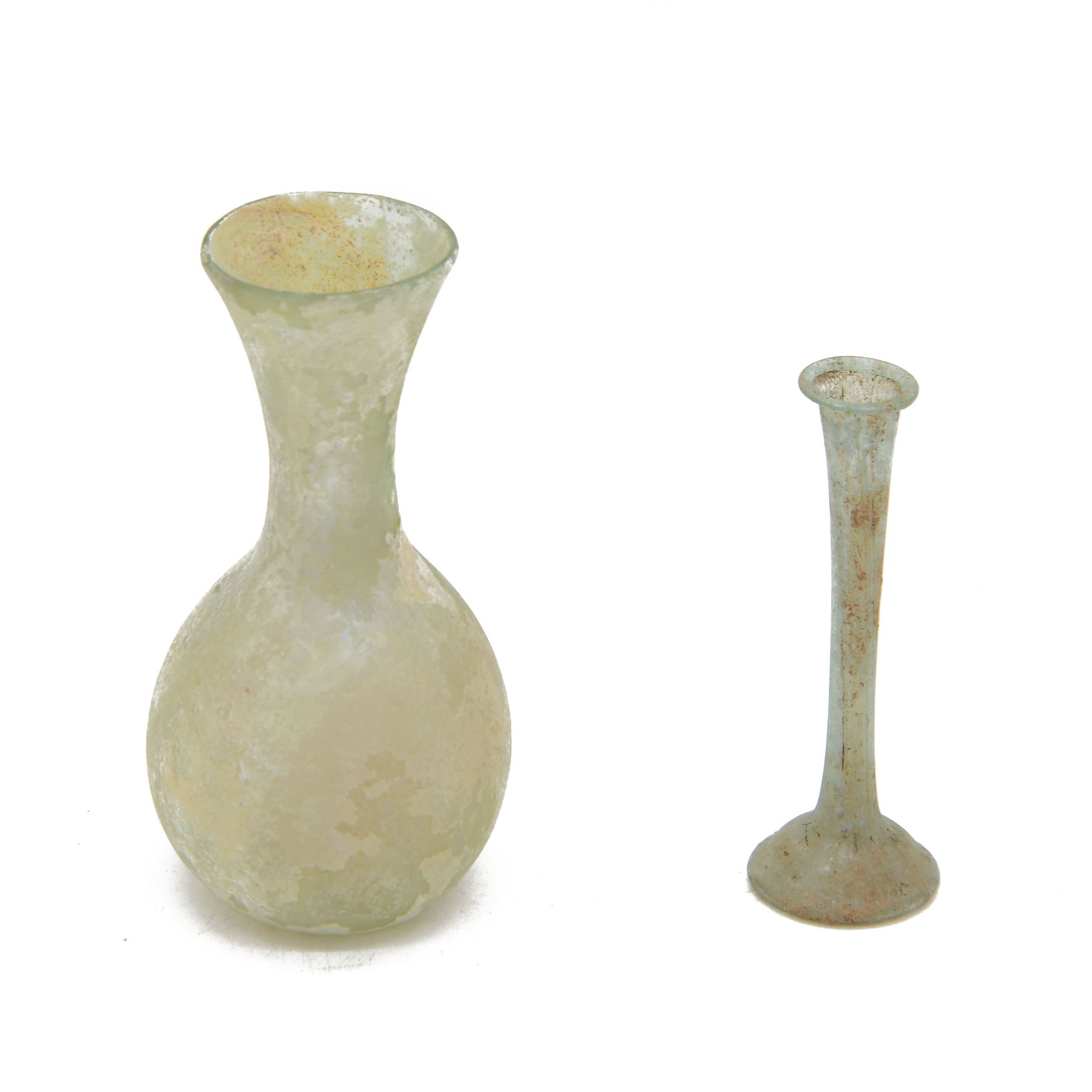 Two Roman glass funerary items, circa 1st century AD, comprising lachrymatory or tear bottle and glass unguentarium, tear bottle H10cm, unguentarium bottle H12cm
teardrop bottles were used by hired mourner to collect the tears at a funeral for the departed, unguentarium bottles housed oils or perfumes for the departed in the afterlife
By vendors repute items discovered in the Dead Sea area of the Holy Lands in the 1960s