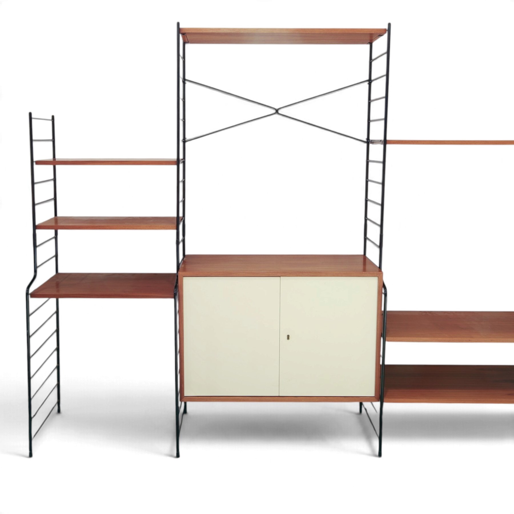 WHB - 'Ladderax' 1960s German modular shelving wall unit, comprising two teak cabinets with white doors, a further fall front teak cabinet with white front, a drawer section with three drawers with recessed handles, multiple shelving sections, raised on metal ladder frames, with further spare sections

Cabinet units: H 47cm, D 36cm, W 71cm
Fall front unit: H 40cm, D 26cm, W 71cm
Shelve widths: 50cm, 71cm 
Shelve depths: 26cm, 36cm