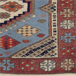 Caucasian Kazak hand-knotted rug, pale blue main field with large geometric medallions in a vertical arrangement and angular tribal motifs within a rosette and geometric border, cotton fringe end, 68x88cm