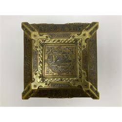 Late 19th century Damascus Cairoware Quran box, of square form with canted hinged cover, upon four circular pad feet, the brass exterior inlaid with silver and copper script and decorative detail, opening to reveal a marquetry lined interior, H15.5cm W19cm D19cm