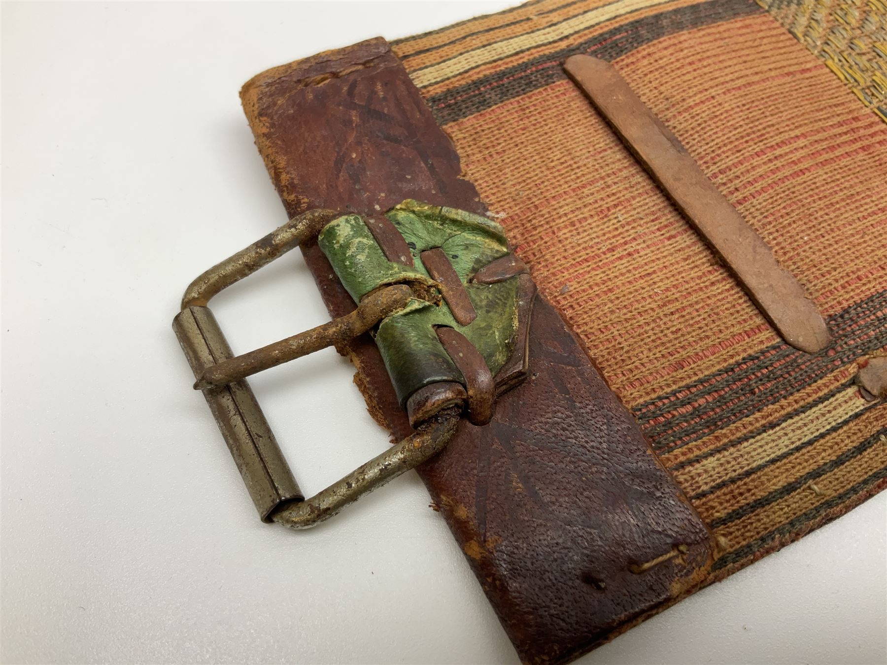Late 19th century Yemeni Tuza jambiya as worn by religious elite, the 20.5cm curving blade with raised medial ridge, the horn hilt with pique style studwork, in a leather wrapped wooden scabbard with pierced metal mount and leather belt applied with embroidered 'gold' and 'silver' thread work panel; dagger L36cm overall, belt L84cm
