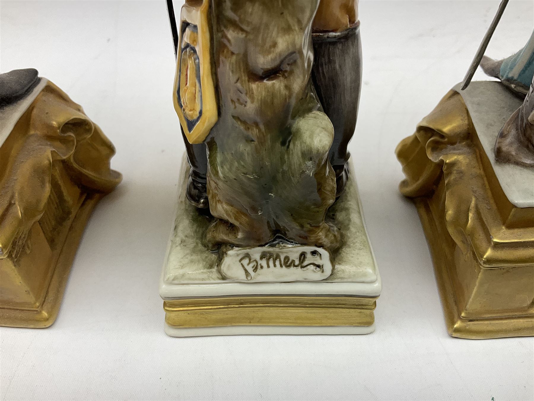 Group of seven Capodimonte figures of soldiers, to include four Bruno-Merli examples including Officer of the 12th Lancers 1820 and Captain of the 18th Hussars 1815, both raised upon ornate gilt plinths bearing British monarch motto in Latin 'Dieu et mon droit', and three further similar, all with crowned N mark beneath, tallest H32cm