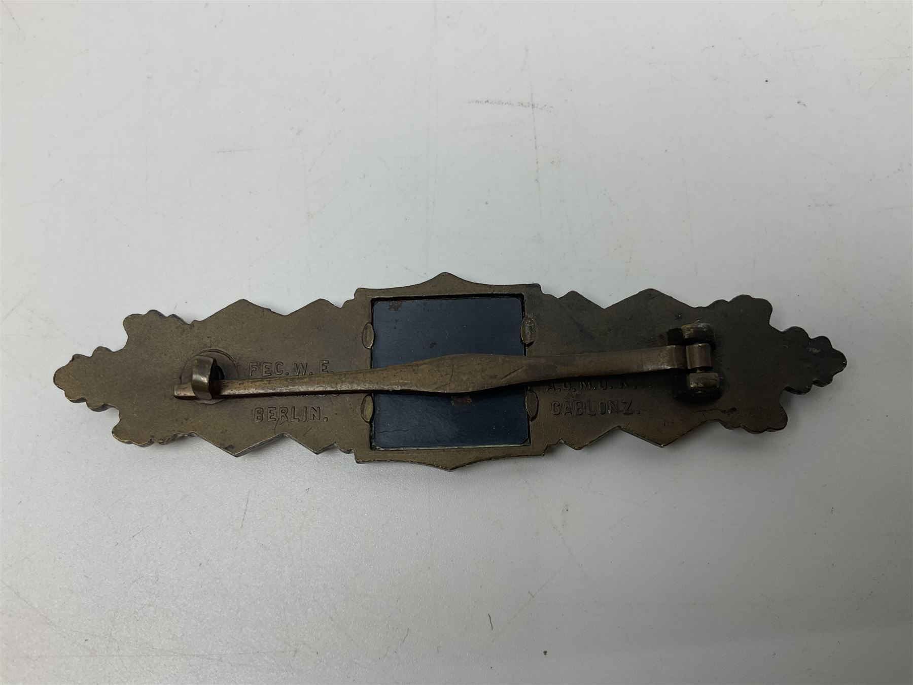 WW2 German Army / Waffen-SS Close Combat Clasp (Nahkampfspange) in bronze with backing plate, original pin and sunken catch; marked verso “FEC.W.E PEEKHAUS BERLIN” and “AUSF. A.G.M. u. K GABLONZ” L9.5cm