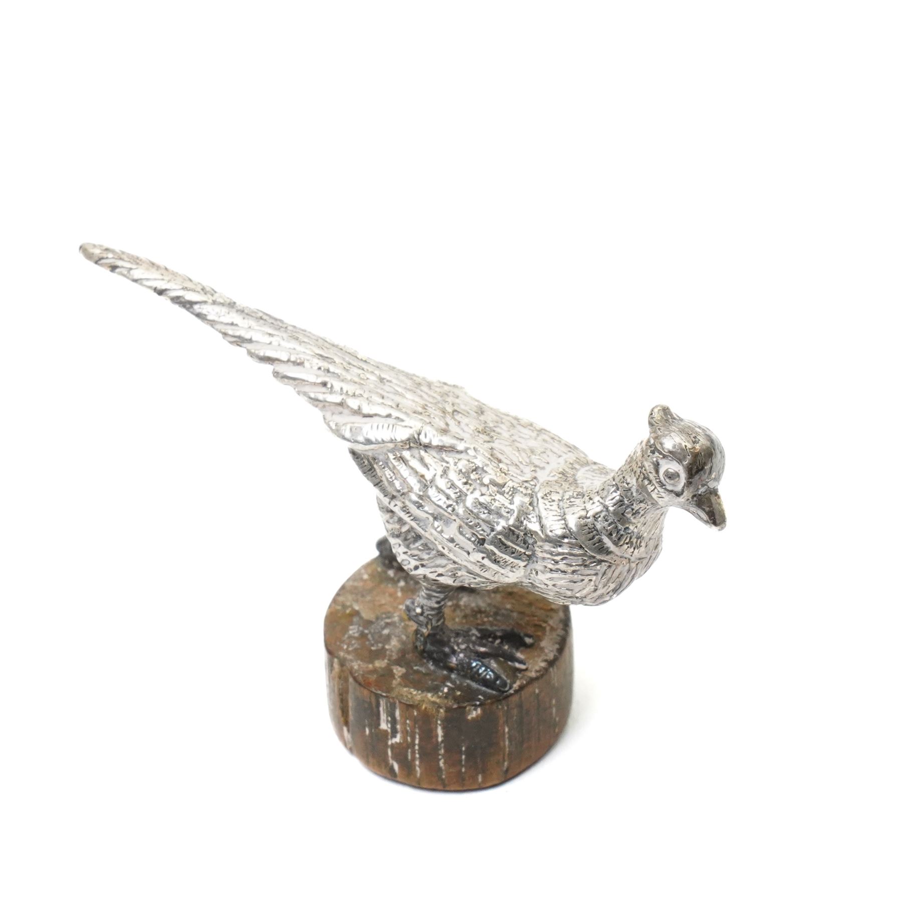 Silver model of a bird perched on a branch and with wooden base by Goldsmiths and Silversmiths Co. H5cm, small silver model of a pheasant on wooden base H2.5cm and a silver miniature model of a dog in a basket marked 925 and indistinct maker's mark L3.5cm (3)