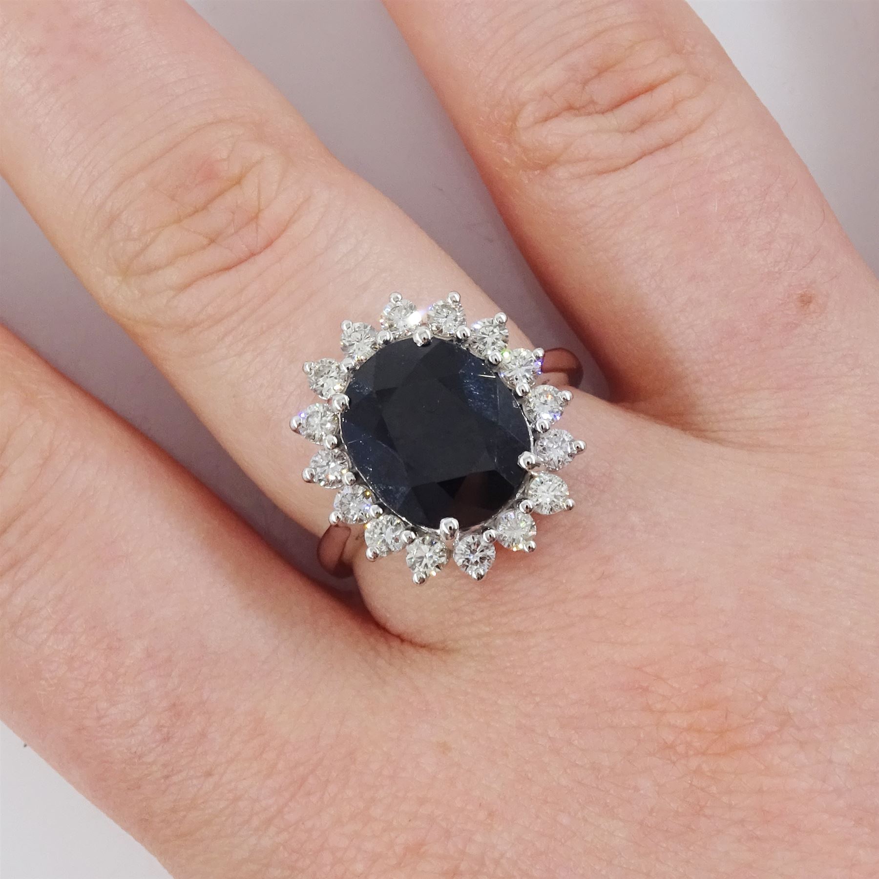 18ct white gold sapphire and diamond cluster ring, single oval cut sapphire of 4.33 carat, with round brilliant cut diamond surround, stamped 750, total diamond weight 0.72 carat