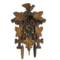 Three 20th century cuckoo clocks and a selection of weights.
