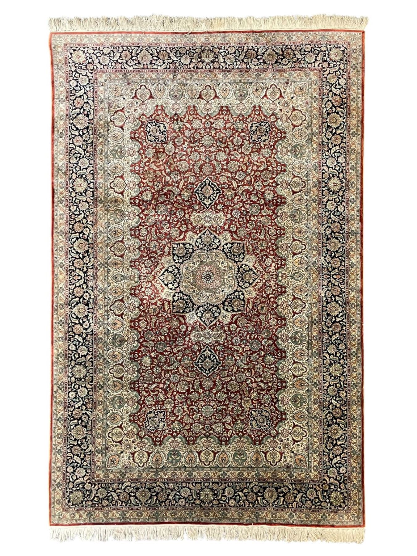Persian silk finely knotted rug, central floral rosette medallion surrounded by curling branches decorated with palmettes, repeating pattern borders decorated with stylised plants and trailing leafy branches  