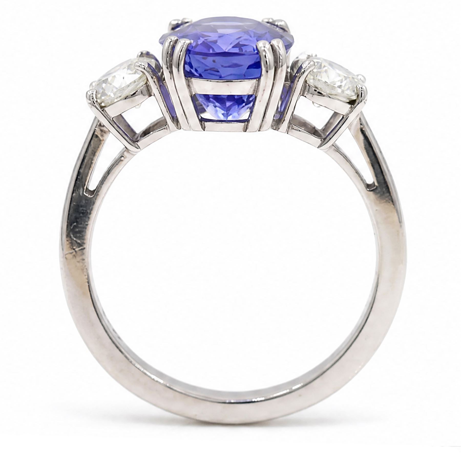 Platinum tanzanite and diamond three stone ring, single oval cut tanzanite of approx 3.55 carat, with a round brilliant cut diamond set either side, total diamond weight approx 0.80 carat