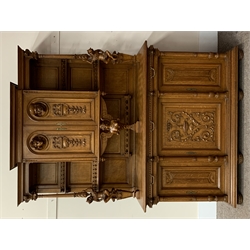 Late 19th century Flemish oak dresser, projecting cornice over two arched panelled doors with carved busts and relief carved ribbons and leafage, two fluted and acanthus carved supports with carved jester figures, central winged maiden support, moulded rectangular lozenge pattern top, three gadroon carved drawers above three panelled doors, the centre door carved with scrolled foliage and urn, stepped moulded plinth, turned and carved feet, W161cm, H227cm, D61cm