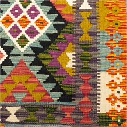 Afghan Maimana flatweave kilim runner, central field features large bold nested diamond motifs and stylized geometric lozenge patterns on olive purple, ochre, blue, and green tone ground, border stripe in orange tones with fringe