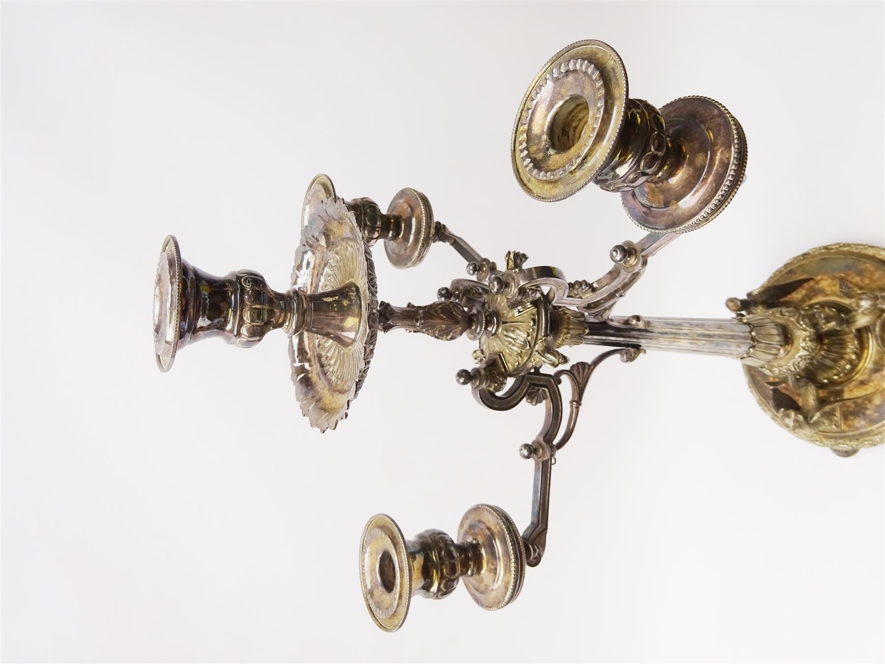 A large Victorian Thomas Bradbury & Sons silver plated candelabrum, the circular base with flower head border upon three domed feet, supporting a central knopped and fluted column flanked by three zoomorphic creatures, leading to a central socket with removable nozzle above a large palmette detailed drip pan, and three scrolling branches with conforming sockets and nozzles, with maker's silver plate mark and Victorian registration lozenge beneath, H62.5cm