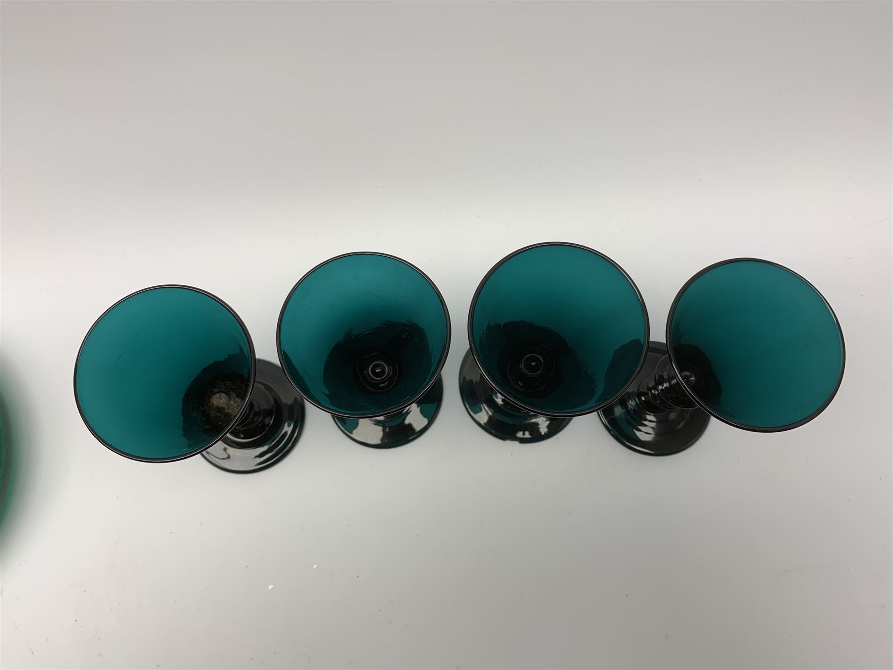 19th century green glass ships decanter with flat topped stopper, H21.5cm, together with a set of four 19th century green glass wine glasses, the funnel bowls upon bladed knopped stems and circular feet, H13cm