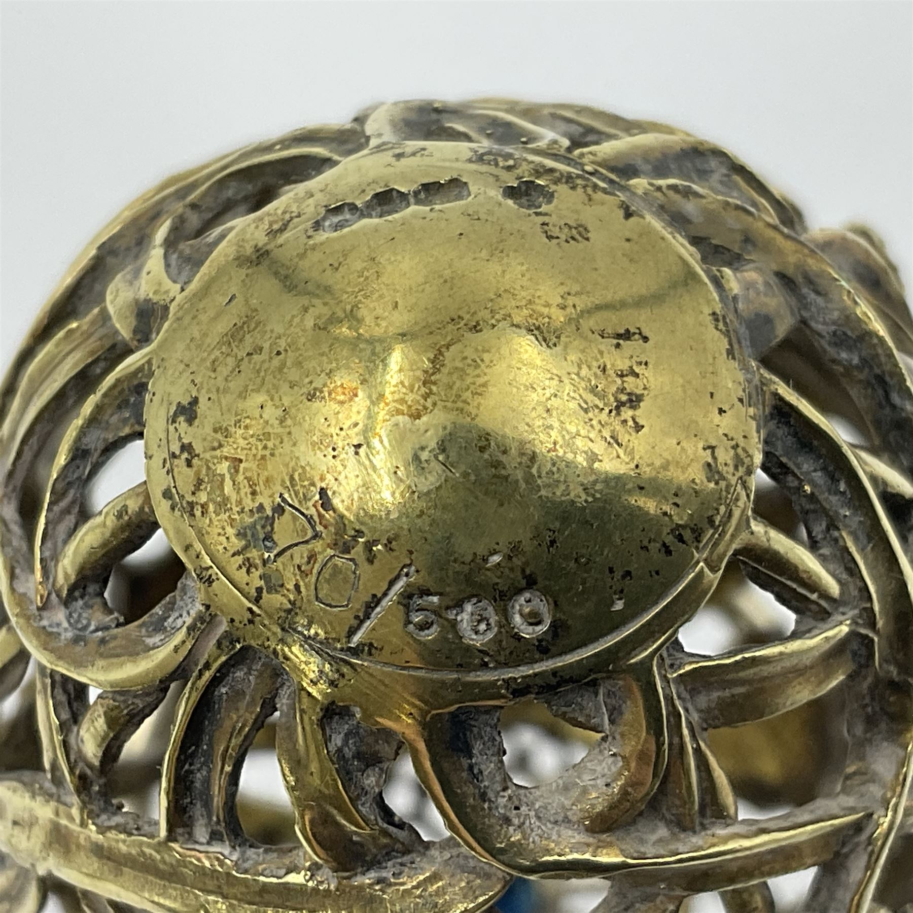 Modern silver limited edition Easter egg, no. 70/500, the gilt openwork body decorated with daffodils and detachable cover with pierced circular panel set with a single faceted blue stone, opening to reveal a gilt interior, upon silver stand with three scrolling pad feet, each hallmarked St James House Company, London 1980, height including stand 8cm