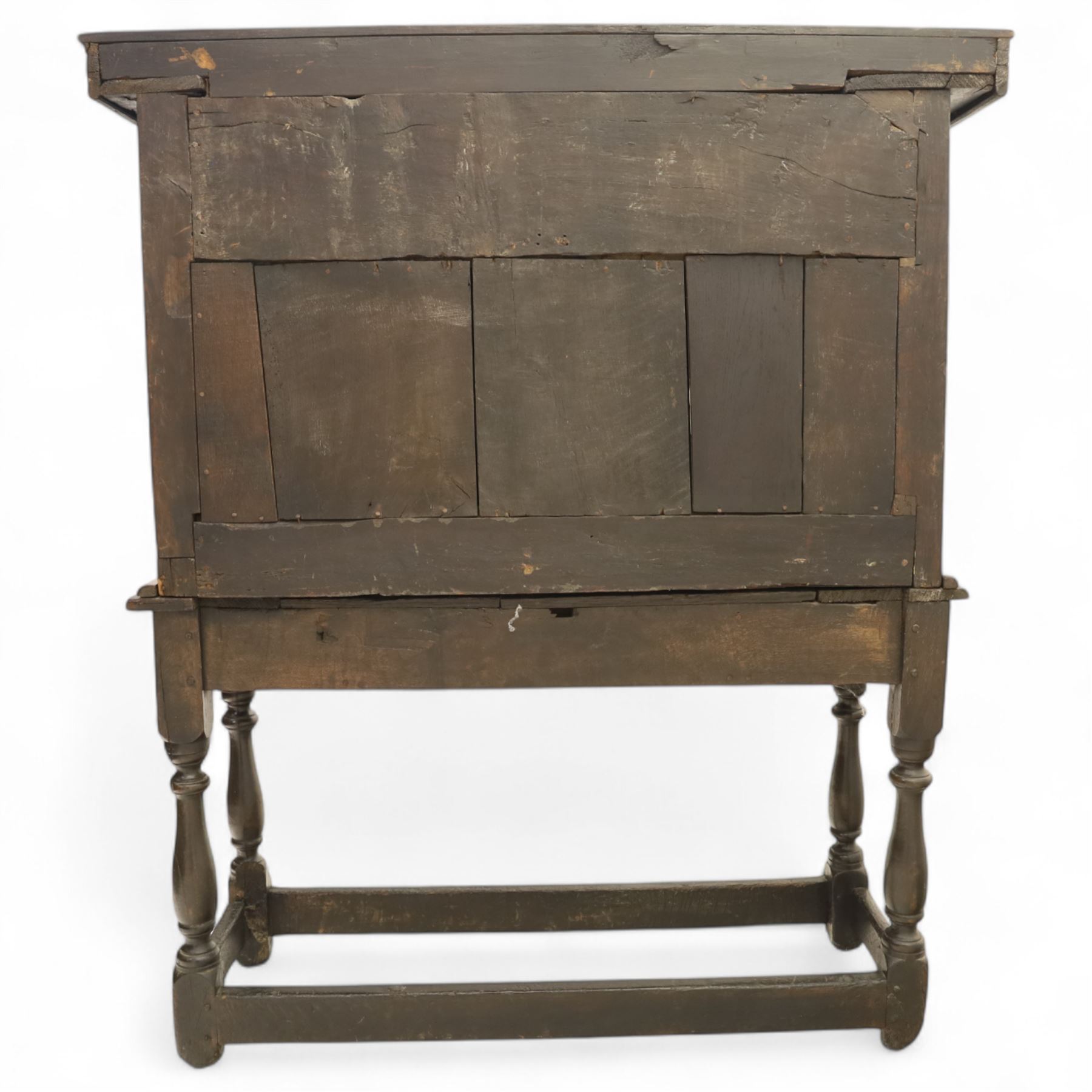 19th century and later carved oak court cupboard, the upper section with two drawers above a central cupboard door flanked by panels, lower section with single long drawer, on turned supports united by carved stretchers