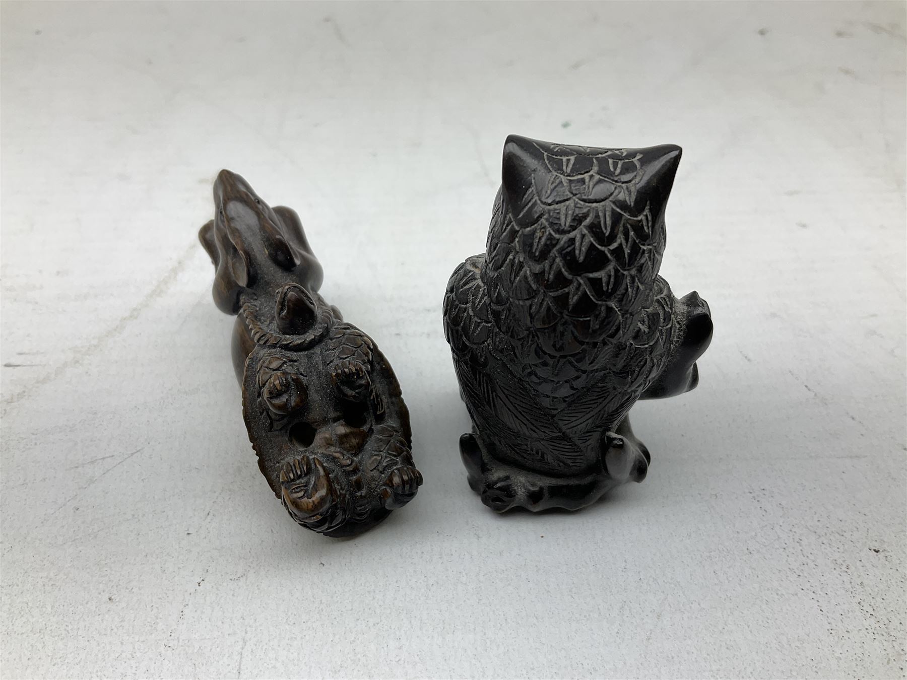 Group of ten Japanese netsukes, comprising eight carved wooden examples, and two ivorine examples, of various form, examples modelled as pigs, owl, mouse with tortoise upon its back, birds, rabbit, etc. 