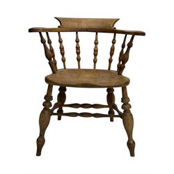 Late 19th century elm smoker’s bow armchair, curved top rails over turned spindle backs, shaped seats, raised on turned legs united by turned stretchers; together with a similar smoker’s bow armchair (2)