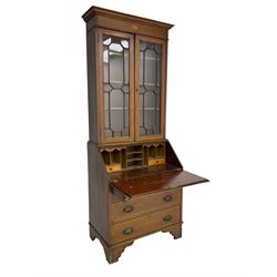 Edwardian inlaid mahogany bureau bookcase, projecting cornice over shell inlaid frieze and two astragal glazed doors, satinwood banding throughout, the fall front inlaid with central urn and extending foliate scrolls, fitted with two short and two long drawers, on bracket feet