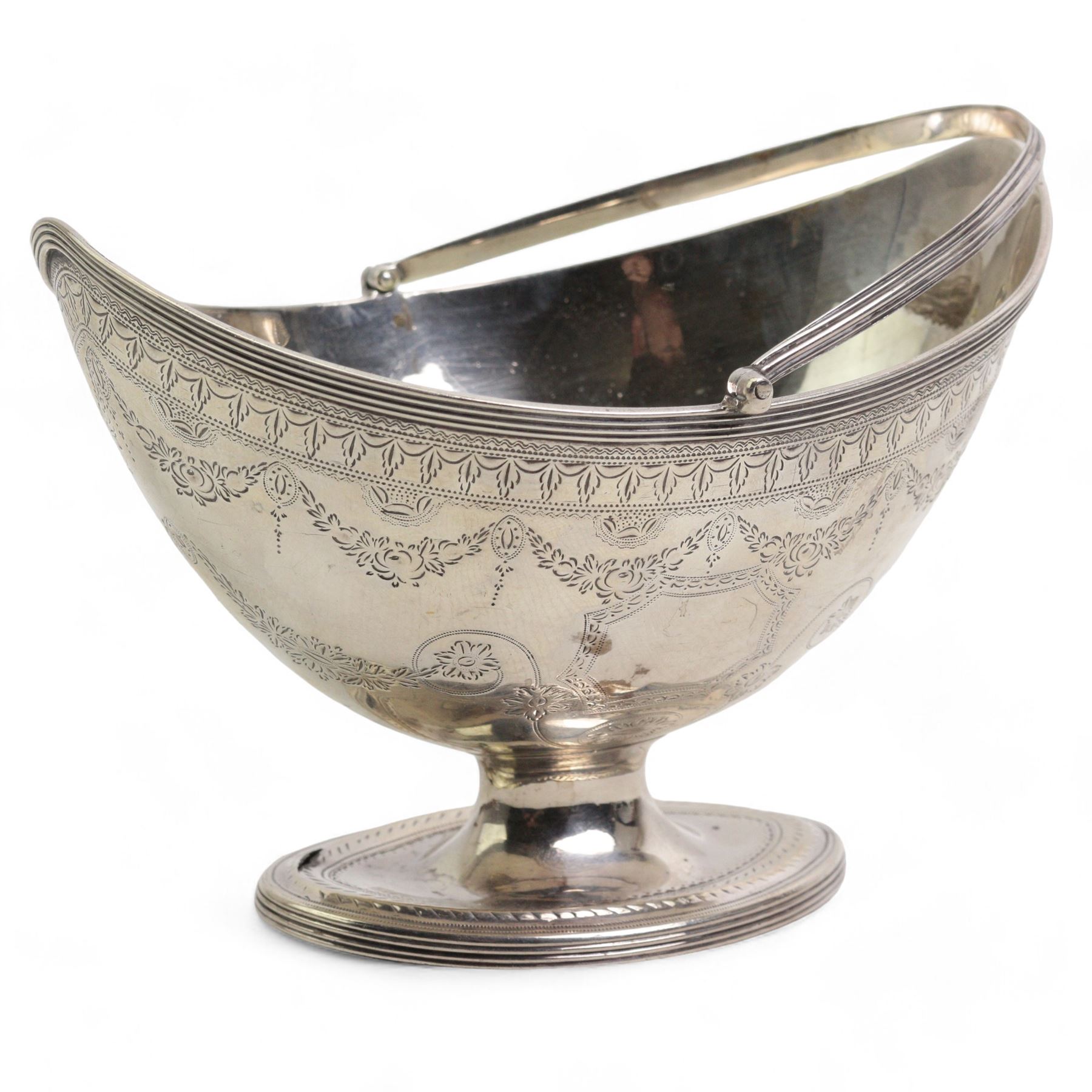 George III silver navette shape sugar basket with reeded loop handle, engraved cartouche and decoration and oval pedestal foot L15cm London 1788 Maker Henry Chawner