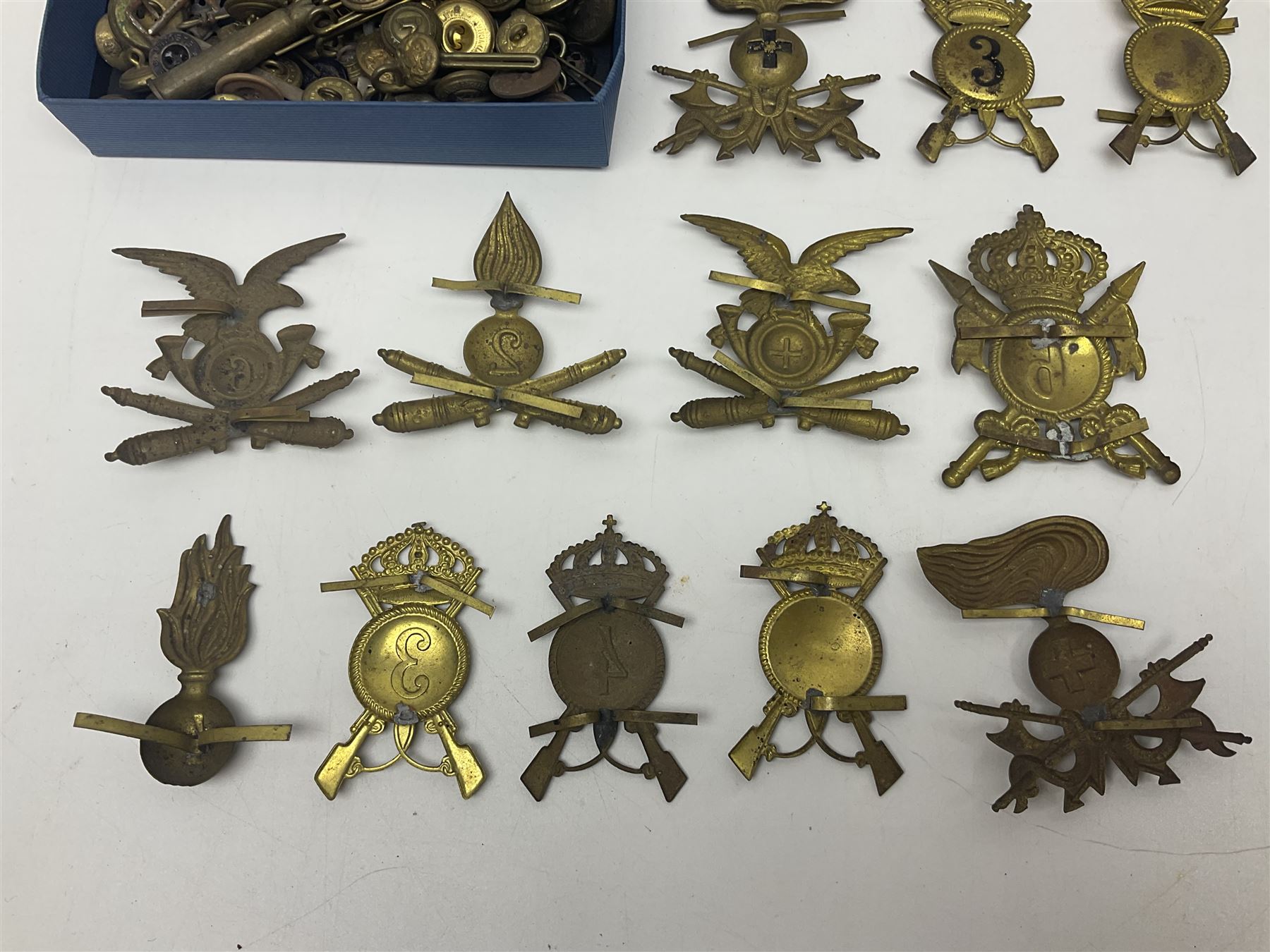 Over thirty British and Continental military metal badges; together with quantity of shoulder titles, collar dogs, rank pips, uniform buttons etc