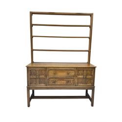Early 20th century oak dresser, four tier plate rack over two panelled cupboards and two drawers 