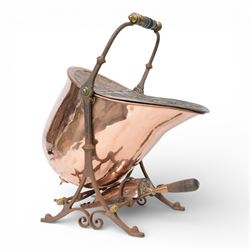 Victorian copper coal scuttle, the helmet shaped body tilting upon stand, with embossed hi...