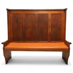 Sid Pollard of Thirsk – late 20th century adzed oak settle, tall panelled back with projecting top rail, shaped arms and tan upholstered drop-in seat, raised on chamfered end supports